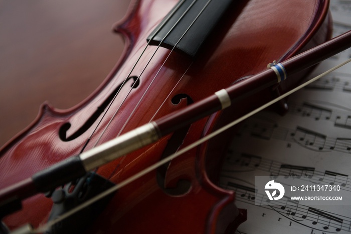 Close up of brown violin with sheet music