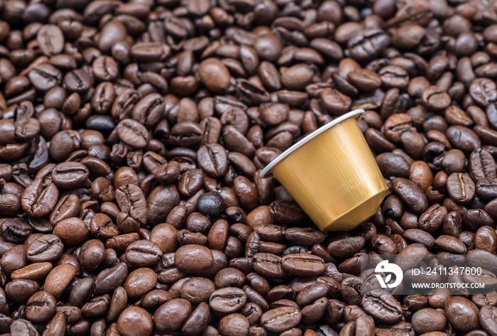 Modern coffee capsule on the roasted coffee bean.