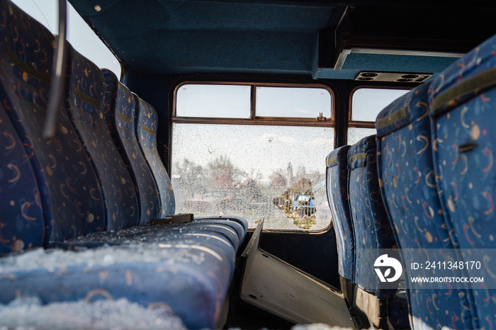 Interior seats with broken windows of the wrecked bus car accident collision traffic after the hooligan vandalism terrorist attack