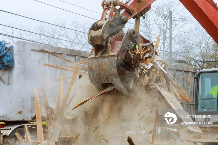 Truck with excavator loads construction waste on a dump truck