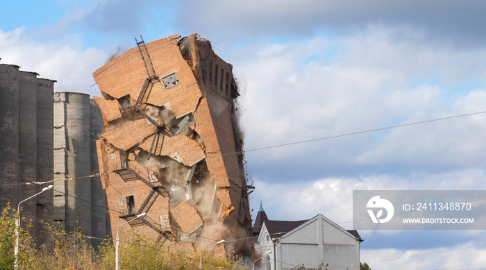 Industrial controlled explosion abandoned building on blue sky with white clouds background. Method for detonating used to set off dynamite bang blast include clearing city area