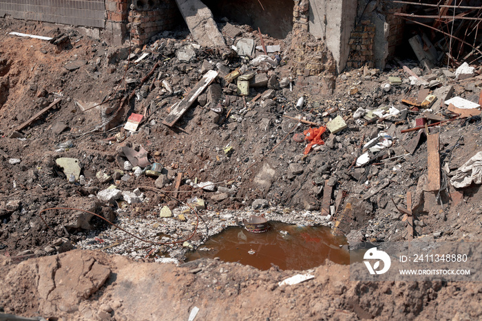 Explosion of an air bomb near the entrance of a residential building. A large crater from an aerial bomb next to a residential high-rise building