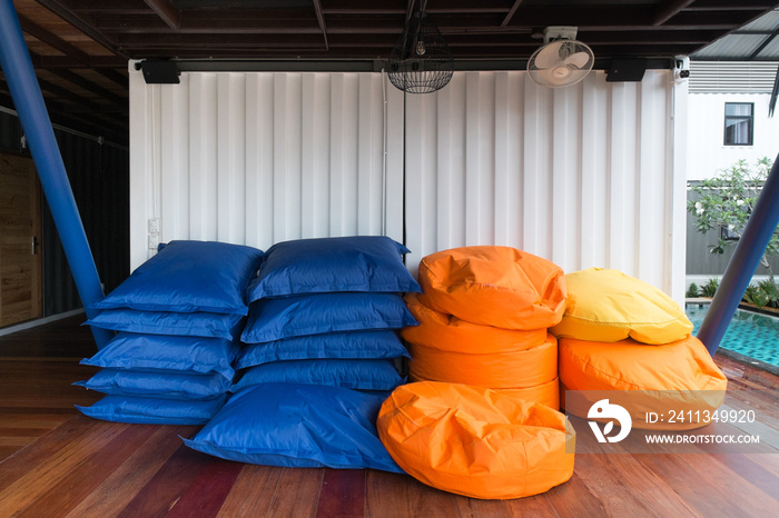 Colorful pile of bean bags with white container wall