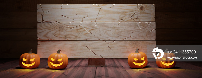 Halloween pumpkins and empty wooden signboard on table. Carved eyes glowing