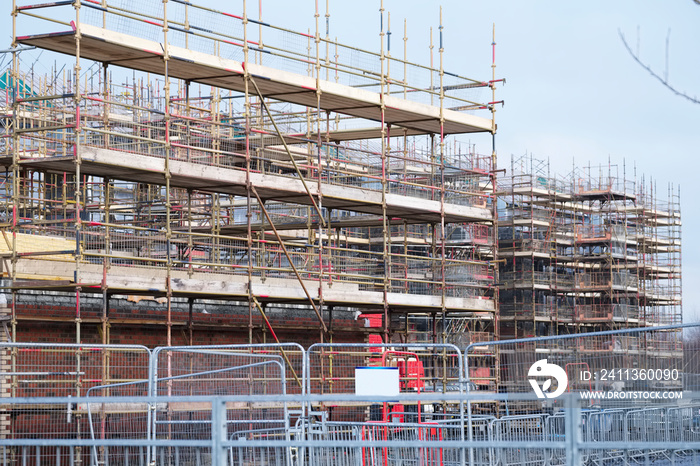 Building affordable homes with scaffolding safety by local construction council to help government social housing problem and shortage England UK