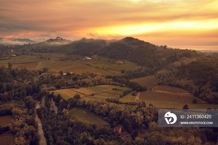 landscape of the stunning hillside  from the village of Gavi, in the background the sanctuary  Santuario della madonna della guardia  in the mist of the sunset, Piedmont, Italy.