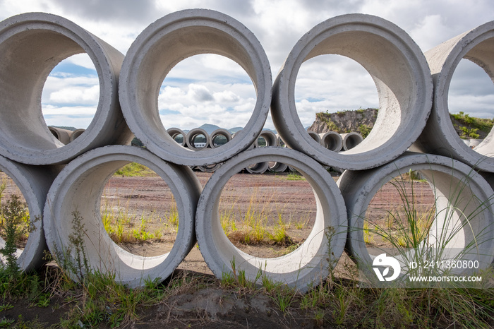 Concrete Shackles piled up in a factory, on a construction site. Basic sanitation works to supply water and sewage to the population. Cement shackles pilled on a lawn.