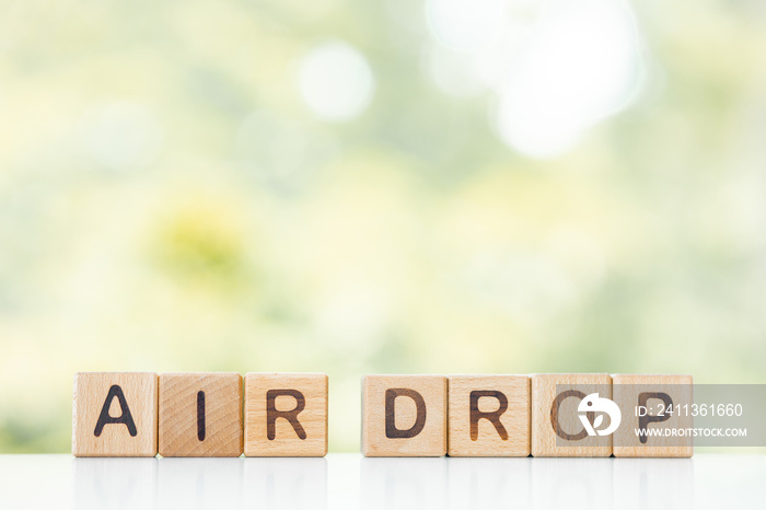 Air drop word is written on wooden cubes on a green summer background Closeup of wooden elements