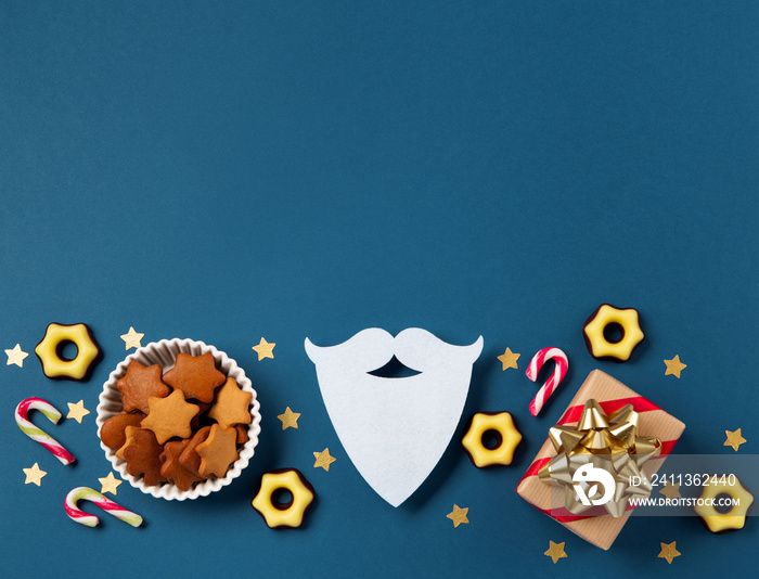 Christmas composition with sweets, candy, gingerbread cookies and gifts on dark blue background, top view.  Saint Nicholas Day, 6 December.