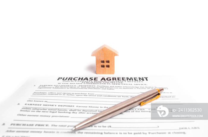 The contract of purchase and wooden house on a white background. The concept of buying and selling real estate, concluding an agreement between the parties. Deal, real estate.