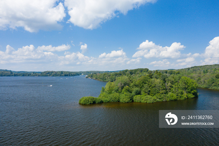 A green island in the middle of the Lac des Settons in Europe, France, Burgundy, Nievre, Morvan, in summer, on a sunny day.