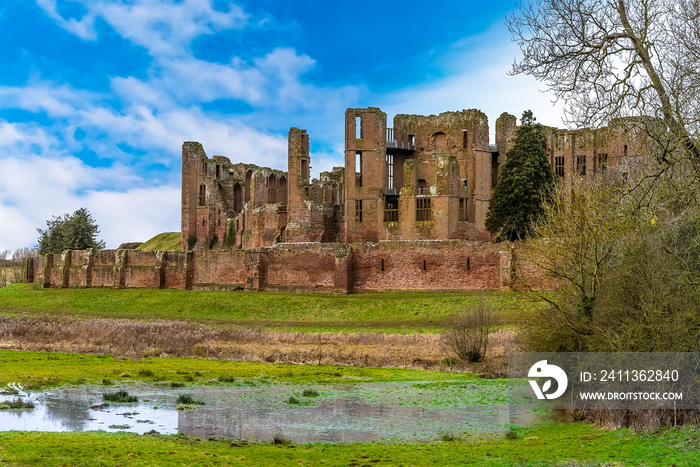 A close-up view across the meadow of the  Great Mere , Kenilworth, UK towards the ruins of Kenilworth castle on a bright winters day