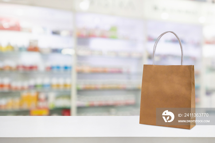 Paper bag on Pharmacy drugstore counter table with medicine and healthcare product on shelves blur background