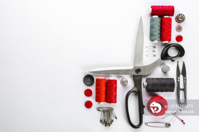 Composition with sewing threads, scissors and accessories on white background, top view