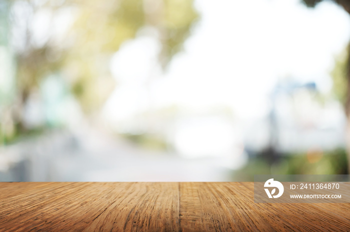 empty wood table top over blur outdoor green nature background.