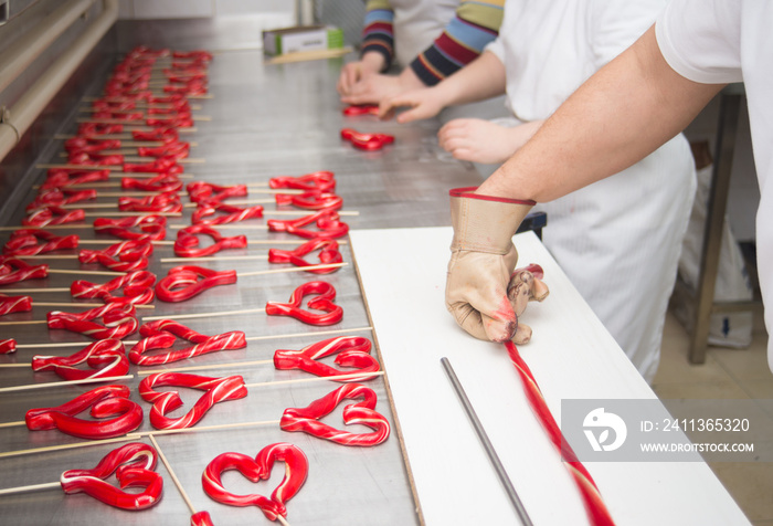 Lollipop making from melted hot sugar in traditional candy workshop