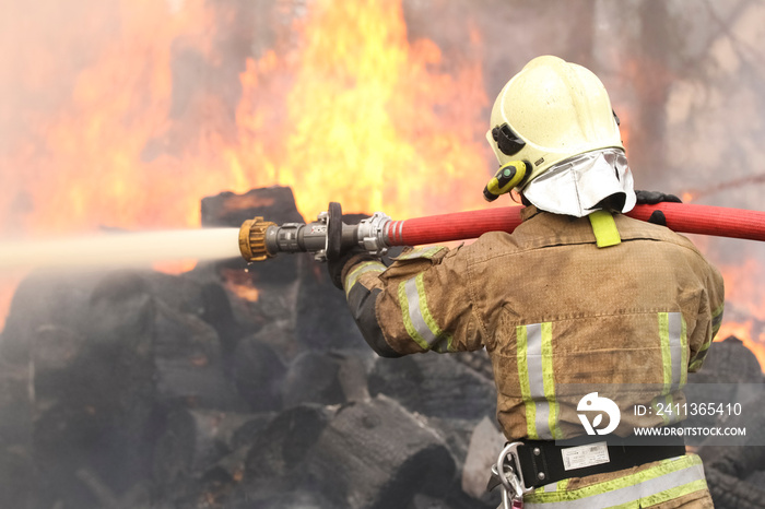 Brave firefighter saving burning building. Firefighter work concept. Firefighter are using water in fire fighting operation. Real brave hero combat the fire