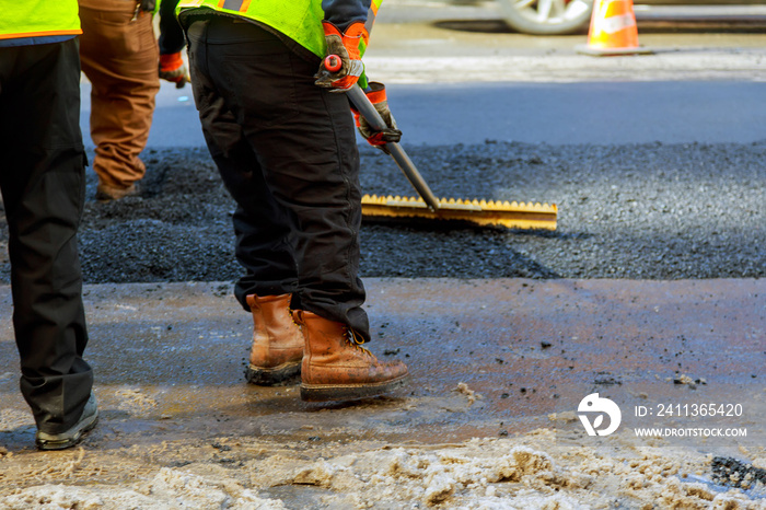 Men hard working asphalting road with shovels