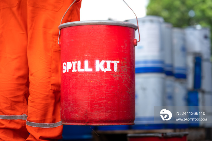 A rescue team is holding red box of  Spill kit , ready to response on chemical spilling accident. Industrial emergency scene photo. Close-up and selective focus.