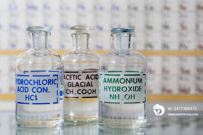 Three reagent bottles containing hydrochloric acid, ammonium hydroxide, and acetic acid.