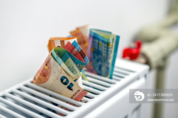 euro banknotes in a central heating radiator, the concept of expensive heating costs, closeup