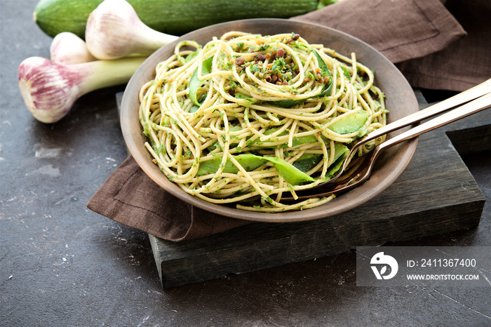 Pasta with zucchini and pesto on dark background. Spaghetti from organic wholegrain flour