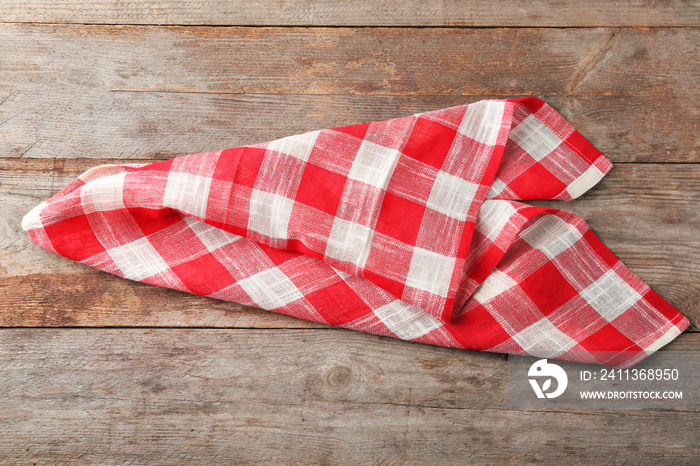 Checkered kitchen towel on wooden background