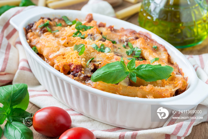 Ziti bolognese in baking dish. Pasta casserole with minced meat, tomato sauce and cheese, horizontal