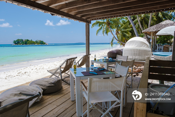 Praslin Seychelles tropical island with withe beaches and palm trees, restaurant with chairs on the beach of Anse Volbert Seychelles.