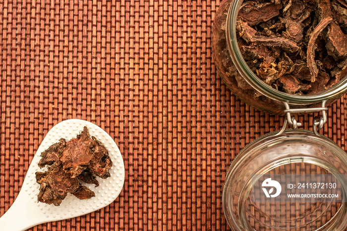 cut dry root of Rhodiola rosea in a glass jar on natural white background