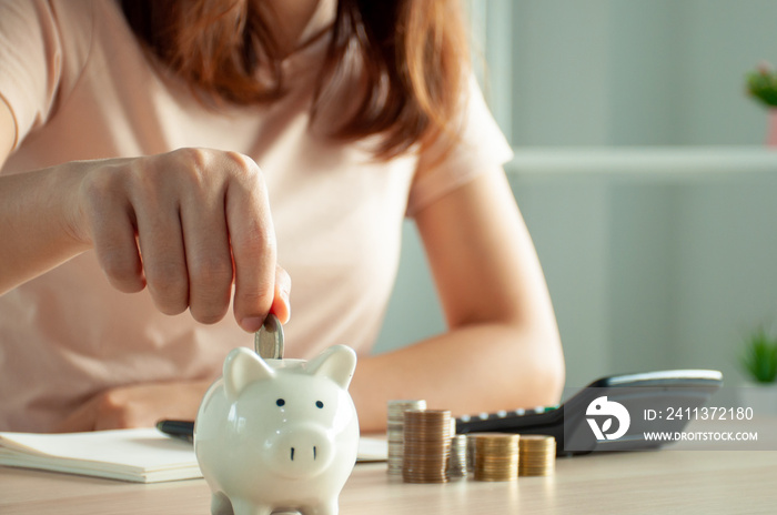 Women are putting coins in a piggy bank for a business that grows for profit and saving money for the future. planning for retirement concept