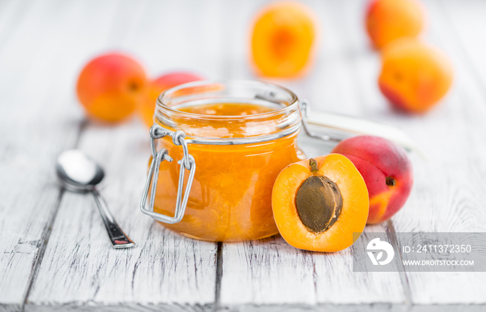 Portion of Apricot Jam on wooden background (selective focus)