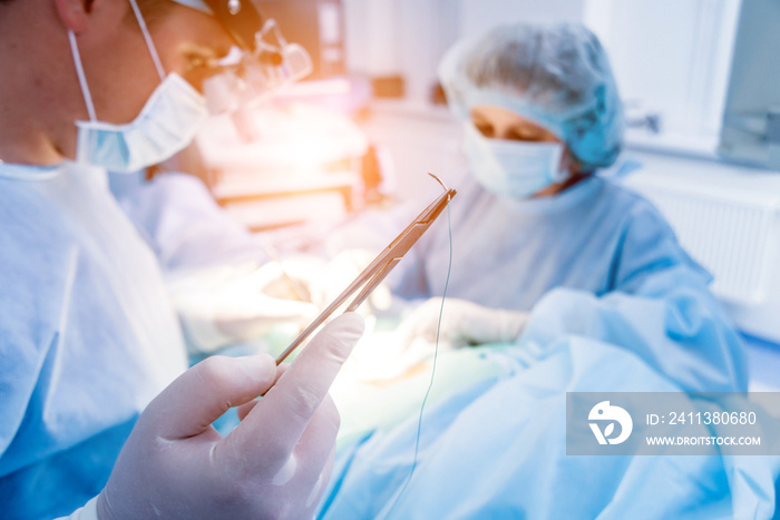 Spinal surgery. Group of surgeons in operating room with surgery equipment. Laminectomy