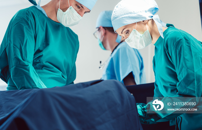 Doctors and surgeons operating patient in hospital with full concentration