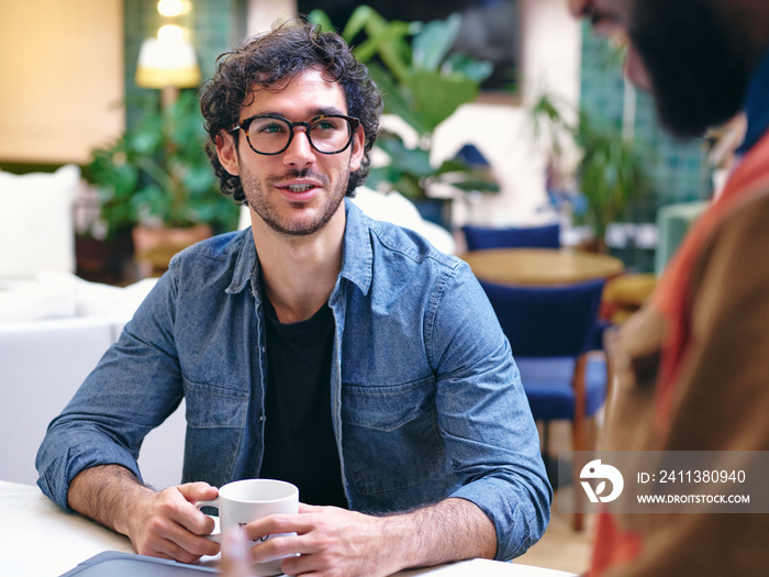 UK, London, Two smiling men talking in creative studio