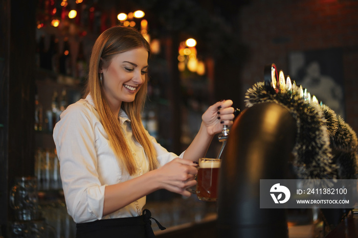 Portrait of happy woman who works as a bartender at bar.