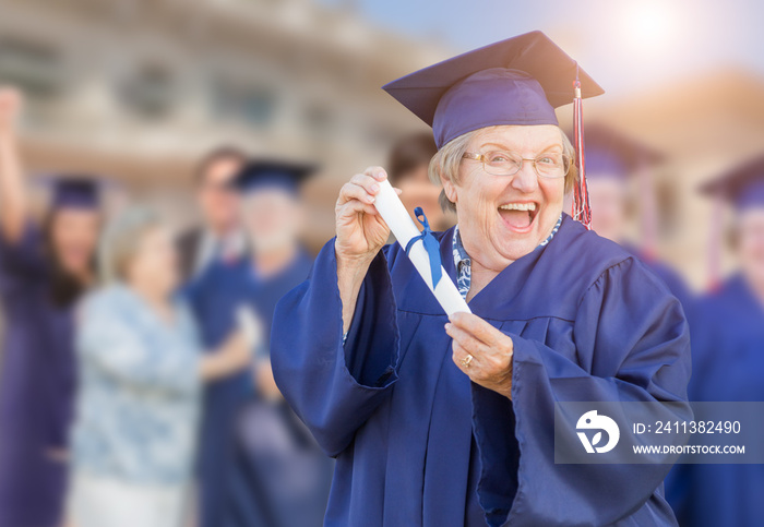 Happy Senior Adult Woman In Cap and Gown At Outdoor Graduation Ceremony.