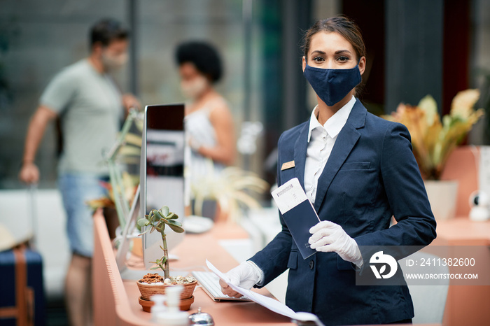 Happy female receptionist with protective face mask working during coronavirus pandemic.