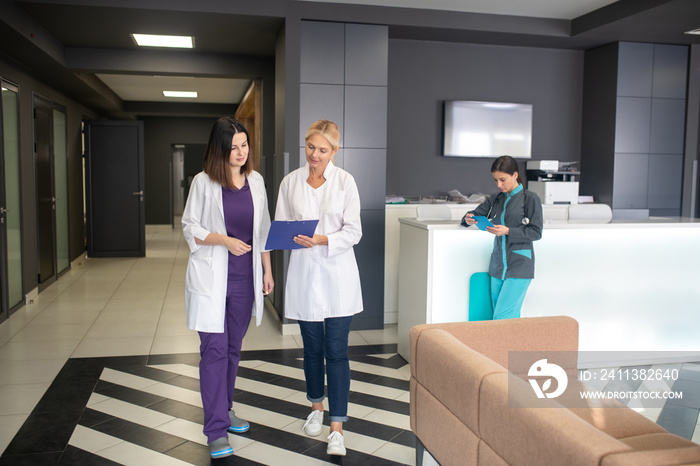 Two female doctors walking in the clinic corridor