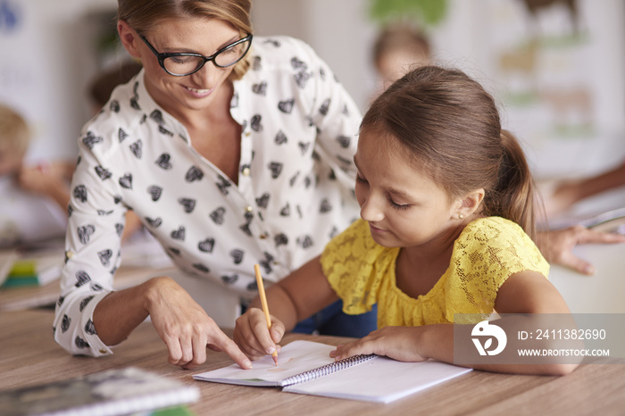 Cheerful teacher helping her student