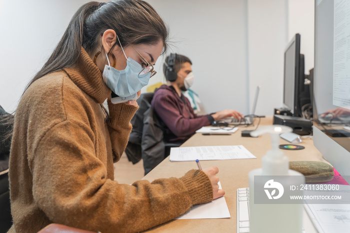 Coronavirus. Business workers working from home wearing protective mask. Small company in quarantine for coronavirus working from home with sanitizer gel. Small company concept.