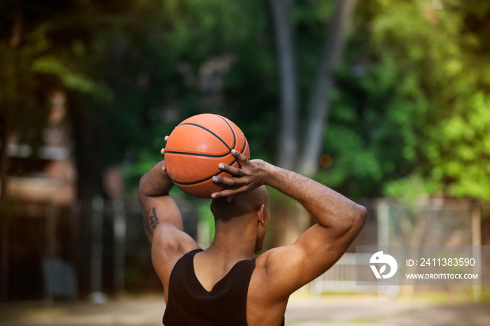 Rear view of basketball player holding ball behind head