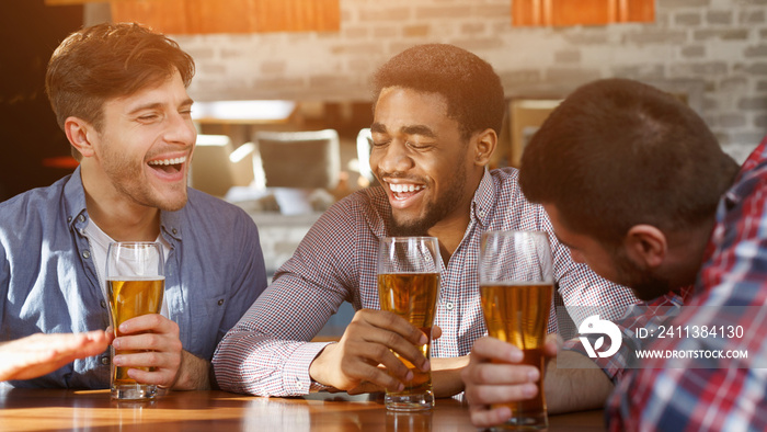 Best friends having fun and drinking beer at bar counter