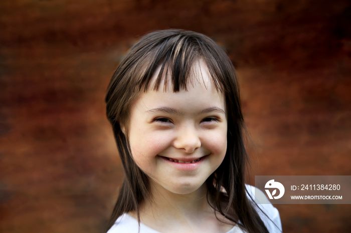 Portrait of little girl smiling on brown background