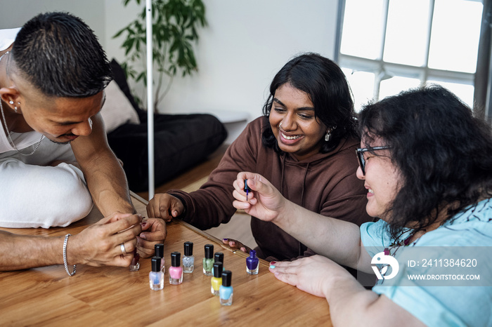 Three friends painting their nails together at home