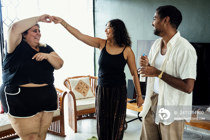 Friends dancing and singing together at home on a weekend