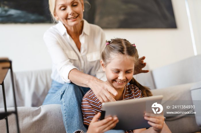 White mother and daughter using tablet computer together at home