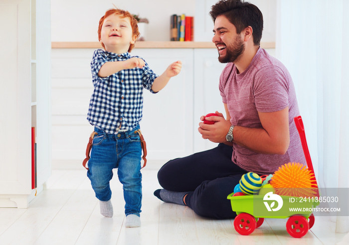 candid moment of happy father playing with cute baby son at home, family games