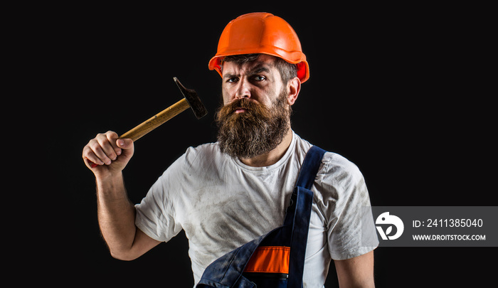 Bearded man worker with beard, building helmet, hard hat. Hammer hammering. Builder in helmet, hammer, handyman, builders in hardhat.