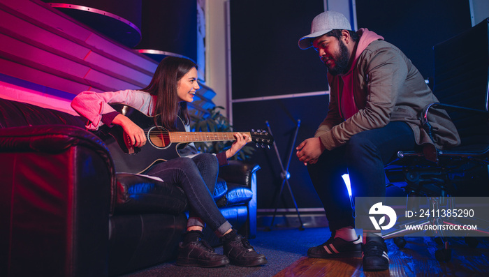 Man and woman composing a song on the guitar